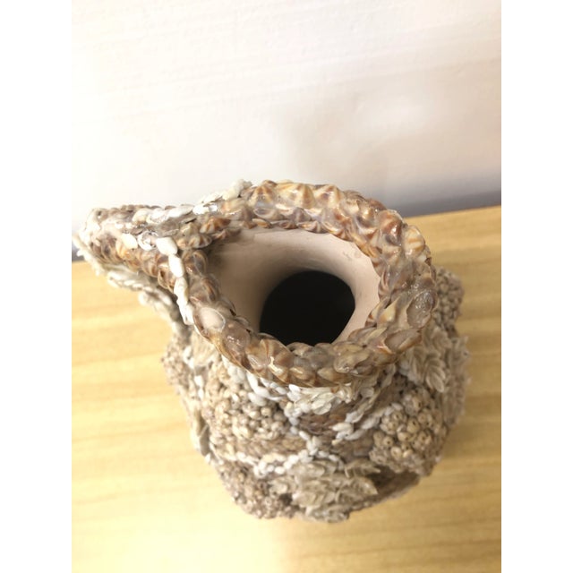 Extraordinarily detailed seashell encrusted ceramic pitcher with a grapevine design made of shells including seed shell....