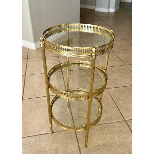 French smaller scale round three-tier brass side or end table with glass shelf insets. Nice detailing including reeded...