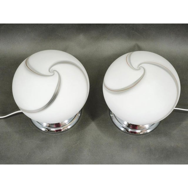 Beautiful pair of Italian Murano glass table lamps from the 1960s, featuring sculptural spherical white glass shades...