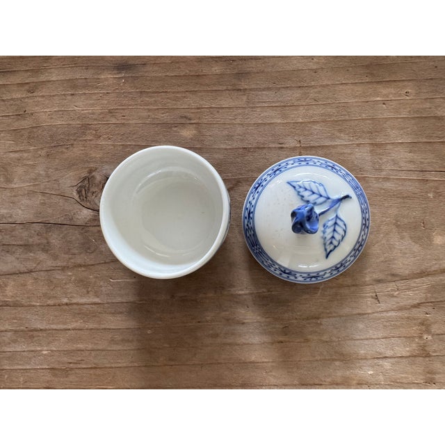 A charming miniature porcelain covered dish in the classic Blue Onion pattern by Hutschenreuther, a renowned German...