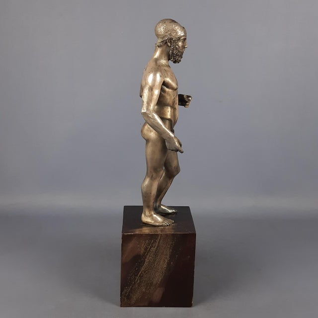 We offer a work of high Italian craftsmanship, a rare and impressive sculptural reproduction of one of the Riace Bronzes...