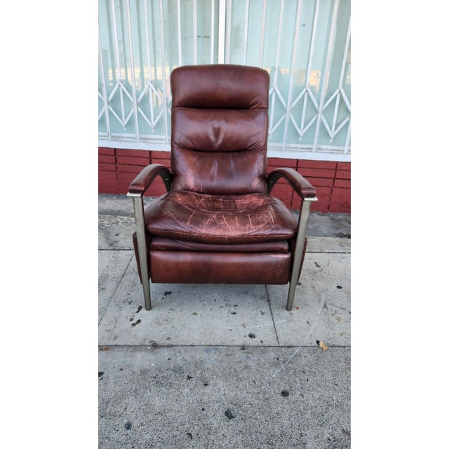 Brown Ethan Allen leather recliner chair is upholstered in genuine top grain leather and features a brushed metal frame....