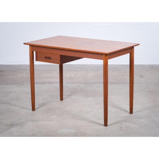 A beautifully preserved teak desk from the 1960s, offering a perfect balance between compact size and practical workspace....