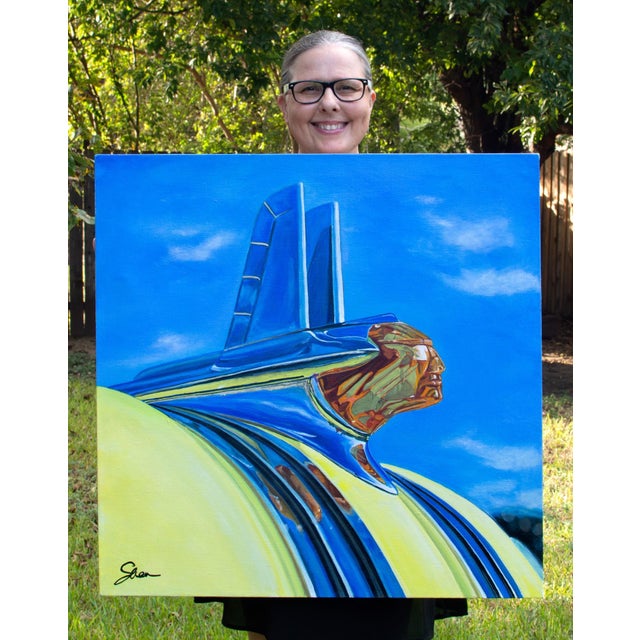 The artwork depicts the iconic hood ornament of a Pontiac Chieftain, rendered with vibrant blues and golds that evoke a...