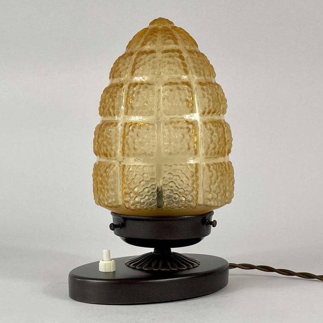 This art deco table lamp was designed and manufactured in sweden in the 1930s. The light features a sculptural amber glass...