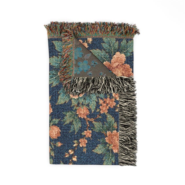 This navy and terracotta floral woven throw blanket features lush blossoms and trailing foliage, textured cotton...