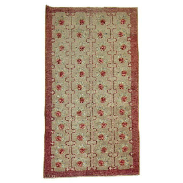 Vintage Turkish Konya rug with repeating floral motif design in raspberry tones on a brown ground. Date found on end...