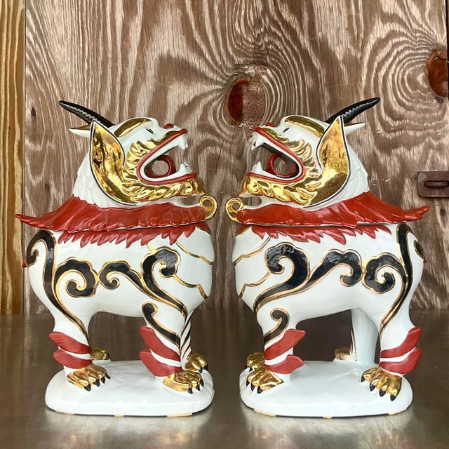 A striking pair of vintage lidded Asian Foo dogs. A chic hand painted porcelaine with gilt tipping. Lots of great secret...