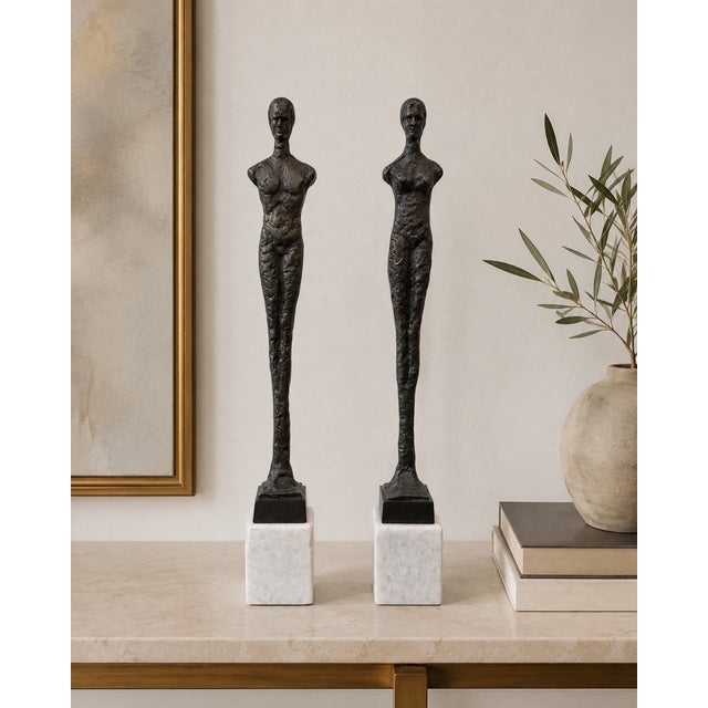 Statement pair of elongated male and female figural sculptures in the style of Alberto Giacometti, each mounted on a...