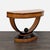 A demilune or crescent shape console made from maple with ebolized accents and inlay along the top. Features two felt...