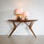 Library table with a distinctive tapering base featuring characteristic sculptural supports, a rectangular top, and an...