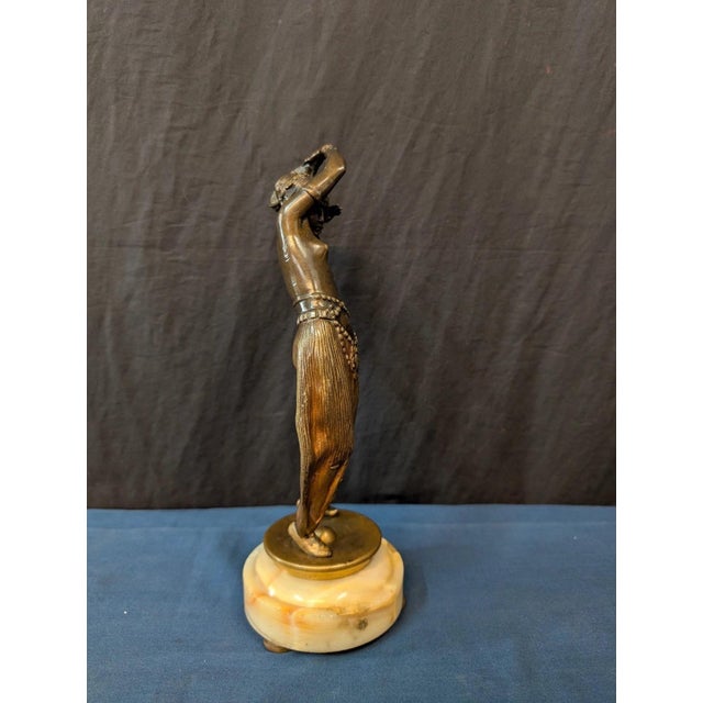 This vintage patinated bronze art deco statue is circa the early twentieth century and is unsigned. Displayed is an...