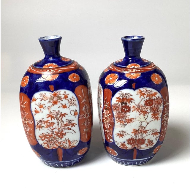 A pair of bulbous classic cobalt blue and iron red Imari vases. The 7.5 inch tall vases with rounded bodies with small...