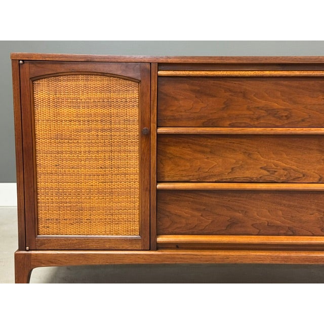 A mid century modern walnut sideboard credenza made by Lane Rhythm with reversible cane doors. Professionally refinished....