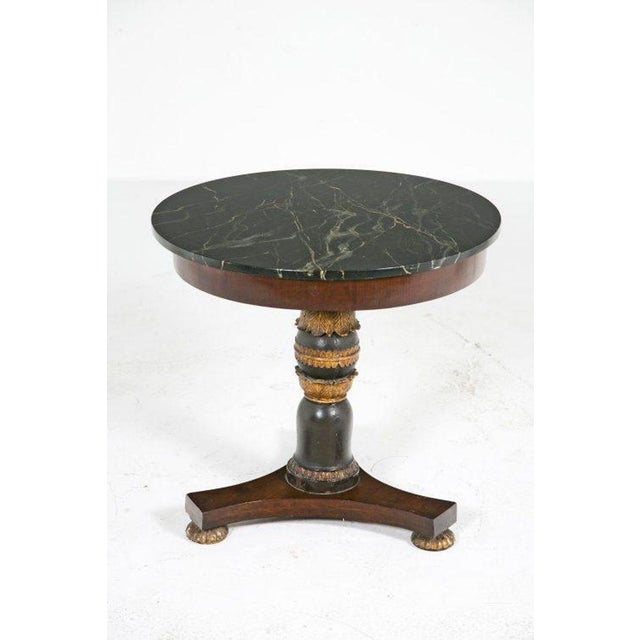A Louis Philippe mid-19th-century table with veined black marble top with a channeled banding to surface edge.