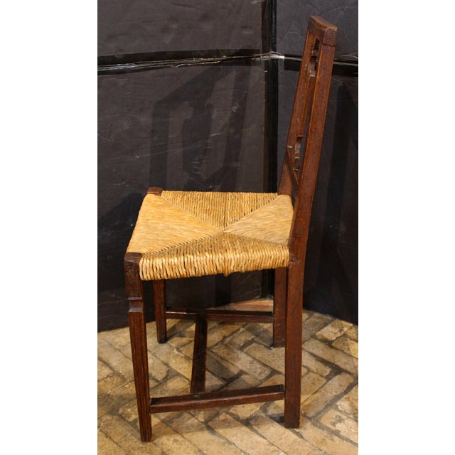 An early 19th century Italian rustic neoclassical side chair. Square back with carved urn backsplat. Rush seat in good...