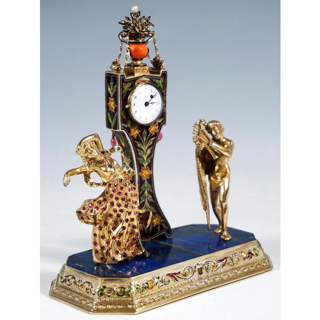 Ornate viennese belle époque table clock in gilt silver with enamel and gemstone inlay, set on a rectangular stepped base...