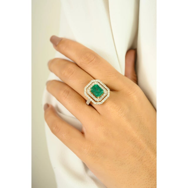 Make a bold statement with this stunning 18K yellow gold ring, showcasing a vibrant 2.06 carat emerald-cut emerald as its...