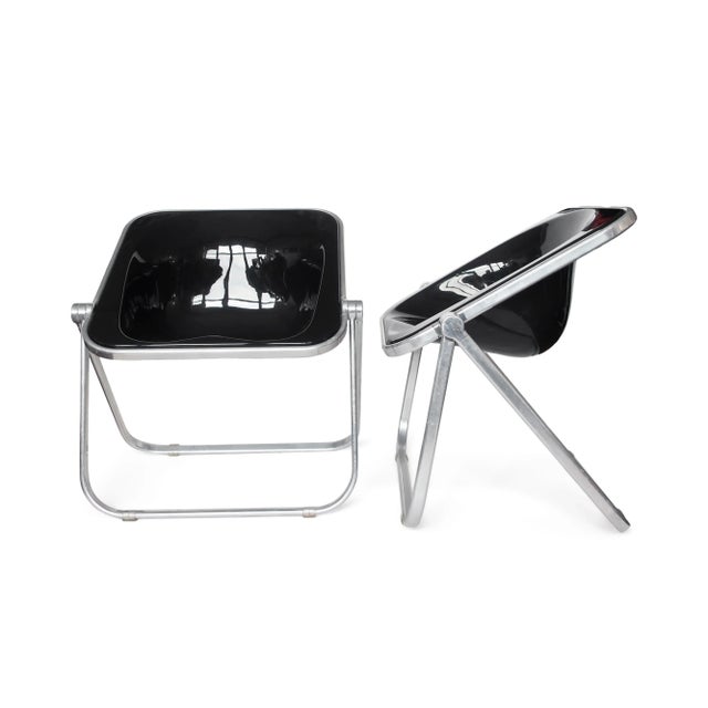 A pair of 1970s Plona folding chairs in black lucite designed by Giancarlo Piretti for Castelli. With a molded acrylic...