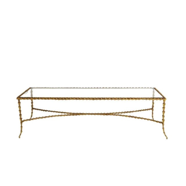 Elegant and sculptural, this gilt bronze and glass coffee table by Paul Ferrante showcases the designer’s signature blend...