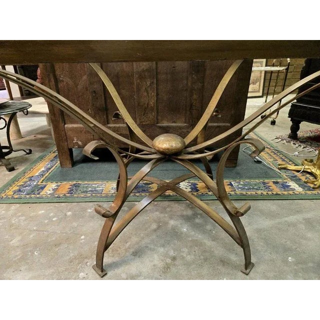 Glass and gilded brass dining table by André Arbus circa 1940.oval shape. Flared legs at the top. Interlaced decoration....