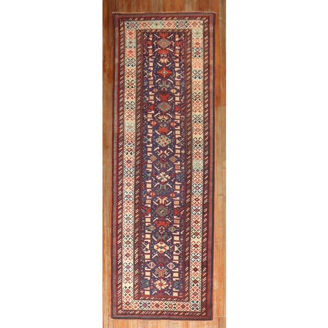 19th century kuba shirvan antique runner with a tribal pattern on a navy color field Measures: 3'11'' x 12'1''.