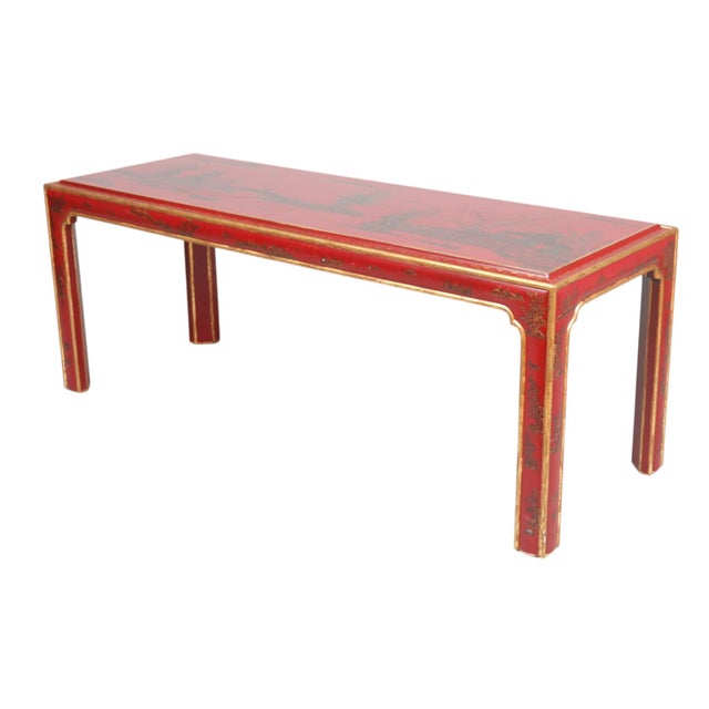 A Chinoiserie red lacquered and gilded coffee table. The top is decorated with pagodas, a river scene, trees, and rockery,...