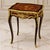 Elegant French-style side table featuring a sophisticated glass top that beautifully showcases the decorative artwork...