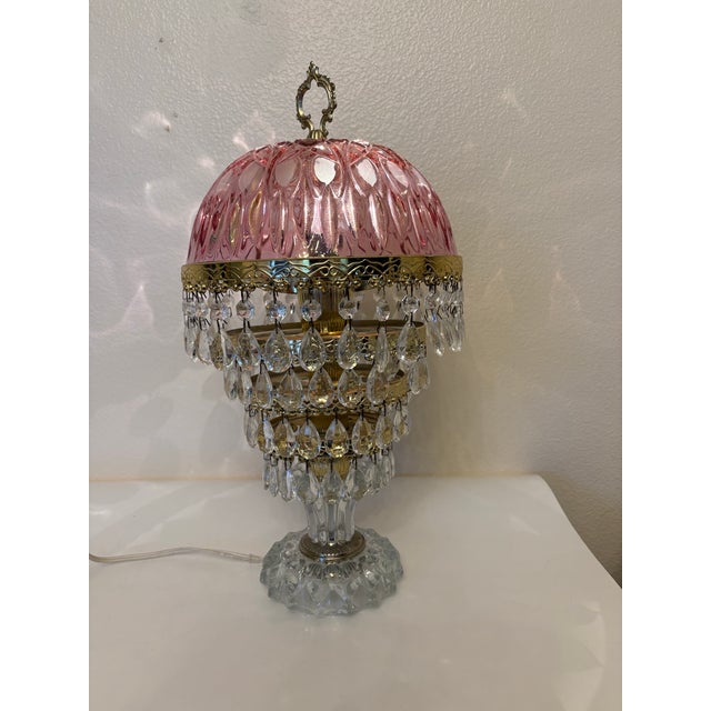 This lamp features a cranberry-pink colored glass domed shade paired with brass-toned hardware and multiple (4) tiers of...