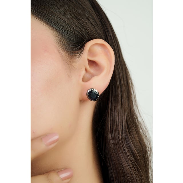 These stud earrings feature 6.97 carats of deep blue sapphires set in 14K white gold. Each sapphire measuring 8.2 x 10.5...