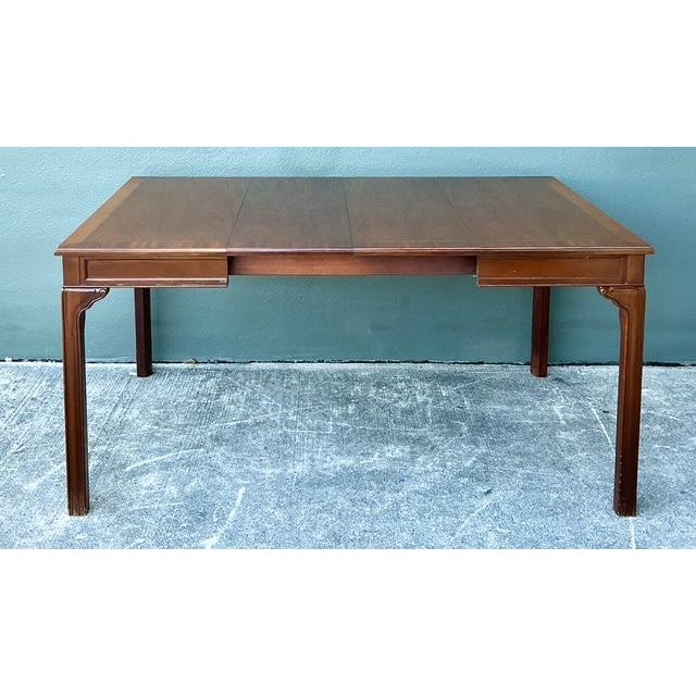 This sophisticated extendable dining table by the prestigious Baker Furniture is a masterclass in versatile traditional...