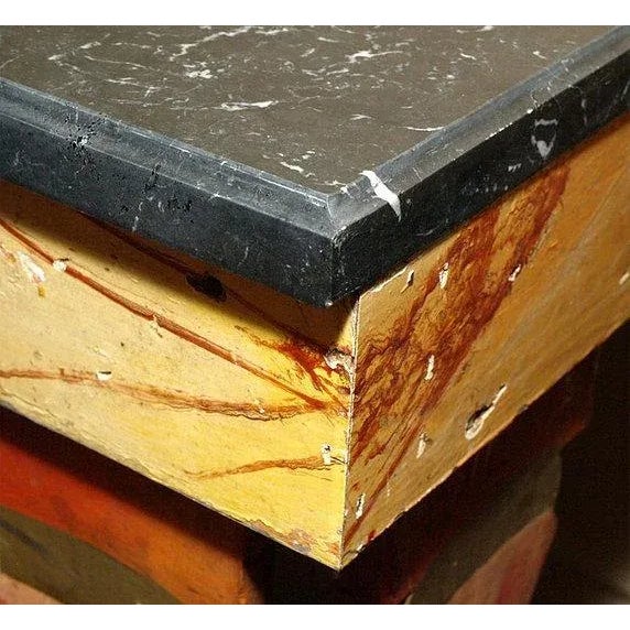 A pair of console tables with marble tops, the console bases made from colorful stylized baluster rails, possibly from a...