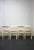 Set of four white lacquered wooden chairs with cane seats. An Italian design from the 1970s. The interplay of the leg...