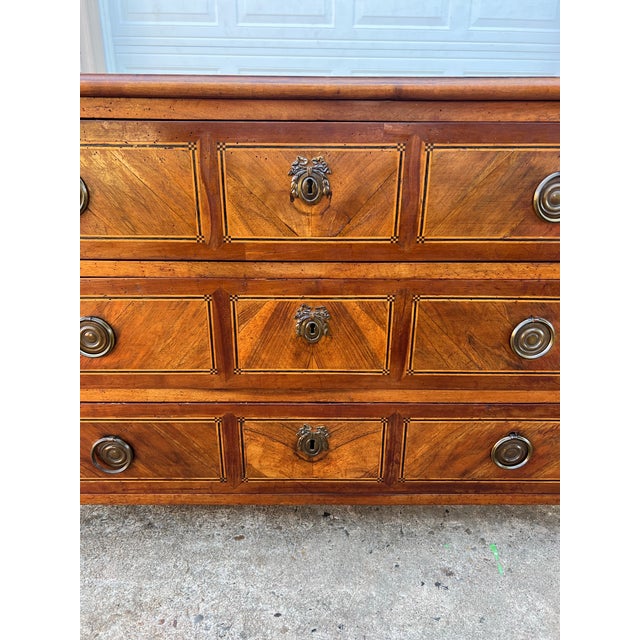 Beautiful 19th-century French Louis XVI commode crafted from solid walnut with elegant geometric paneling and a rich, warm...