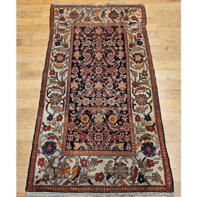 "This exquisite early 20th-century Persian Malayer rug showcases an allover Herati geometric pattern woven in a deep navy...