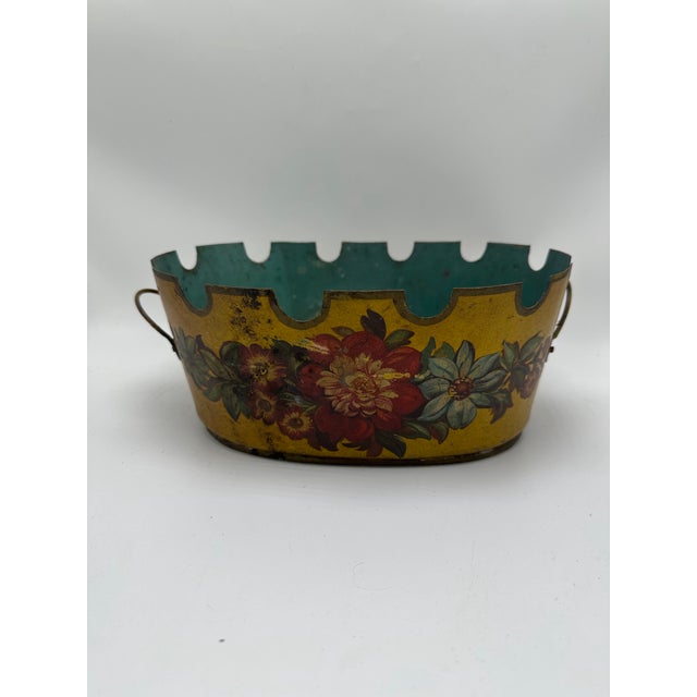 A delightful antique tole planter featuring a warm ochre-yellow ground adorned with hand-painted floral garlands in rich...