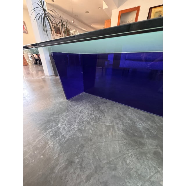 Large sculptural postmodern coffee table featuring a thick tempered glass top with an asymmetrical geometric form and bold...