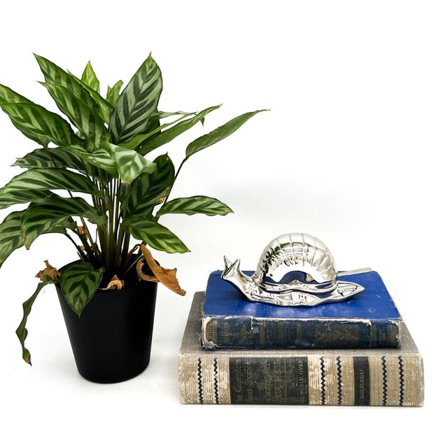 Delightful and unusual caviar dish in the form of a stylized snail, crafted from silver-plated EP zinc alloy. The hinged...