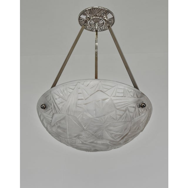 NOVERDY A French 1930s art deco pendant light in nickel plated solid brass holding a bowl in clear frosted molded-pressed...