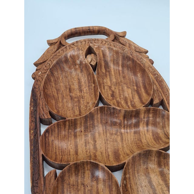 A striking, hand-carved wooden platter / decorative tray, most likely made of teak. The piece originates from India and...