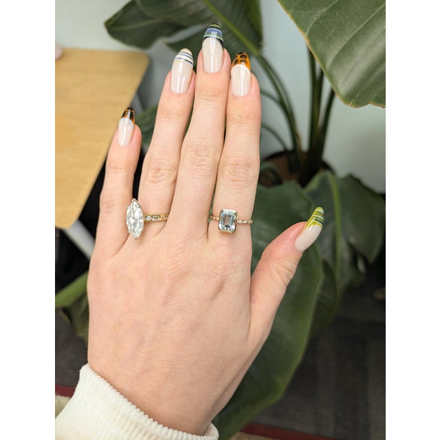 2.2ct Aquamarine ring featuring a 9×7mm oval center stone, accented with natural diamonds for added brilliance. Expertly...