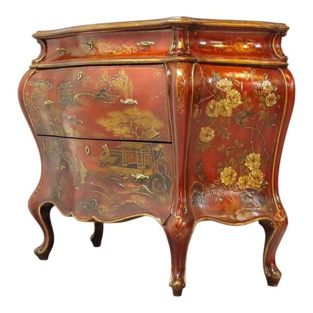 This Bombay chest features a vibrant red lacquer finish adorned with extensive gilded chinoiserie decoration. The bombe-...