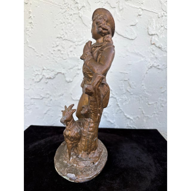 This refined early 20th century French-style figurative sculpture depicts a young shepherd in period dress, elegantly...