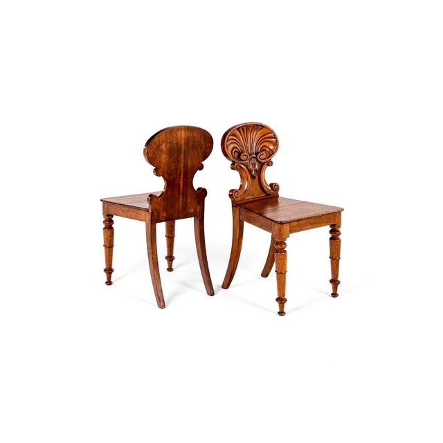 A beautiful pair of carved scallop shell back hall chairs attributed to gillows of lancaster and london. This fine pair of...