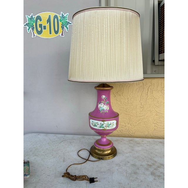 This vintage lamp is pink and decorated with floral and amorous scenes with Victorian ladies of the court, and are set on...