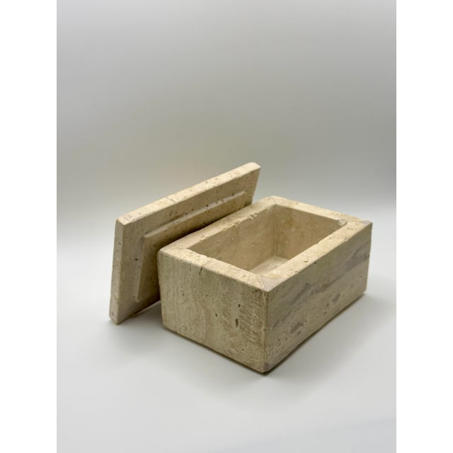 A beautifully crafted solid travertine decorative box featuring clean architectural lines and warm natural stone veining....