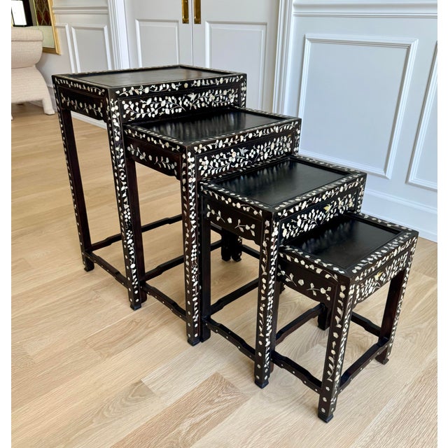 An elegant and increasingly rare graduated set of four vintage Asian export nesting tables, handcrafted from solid...