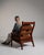 This piece presents as a armchair, distinguished by dark wood frame, cognac/tan leather upholstery. It was made in France...