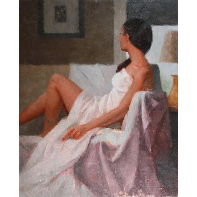 This oil painting captures a figure draped in white, seated in a serene interior space. The soft, natural light...