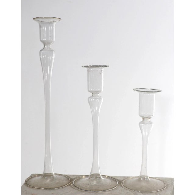 Set of three blown glass candlesticks in graduated sizes, in clear glass, attributed to Dan’s. All three are in very good...